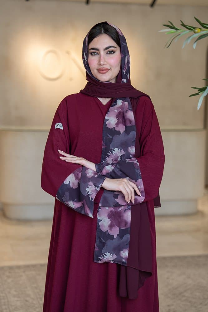 تصميم كريب ماروني بتركيبة أكمام مميزة تألقي بإطلالة أنيقة مع عباية باللون الماروني من قماش الكريب الناعم، تصميم بسيط يبرز بتفصيلة أكمام فريدة تجعلها قطعة لا تمر دون أن تُلاحَظ كريب ماروني بتركيبة أزهار على الأكمام تتميز هذه العباية بتركيبة قماش مطبوع بنقشة أزهار مائية بألوان البنفسجي والموف والرمادي الغامق تمتد على الجزء السفلي من الأكمام، تفصيلة تضيف عمقاً وتميزاً للتصميم في كل حركة الطرحه المتناسقة لإكمال إطلالتك لإضافة لمسة ختامية لإطلالتك، تأتي العباية مع طرحة ثنائية تجمع باللون الماروني مع نفس قماش الأزهار المطبوع لتكمل الإطلالة بتناسق مثالي، ارتديها بثقة في كل يوم يستحق حضورك