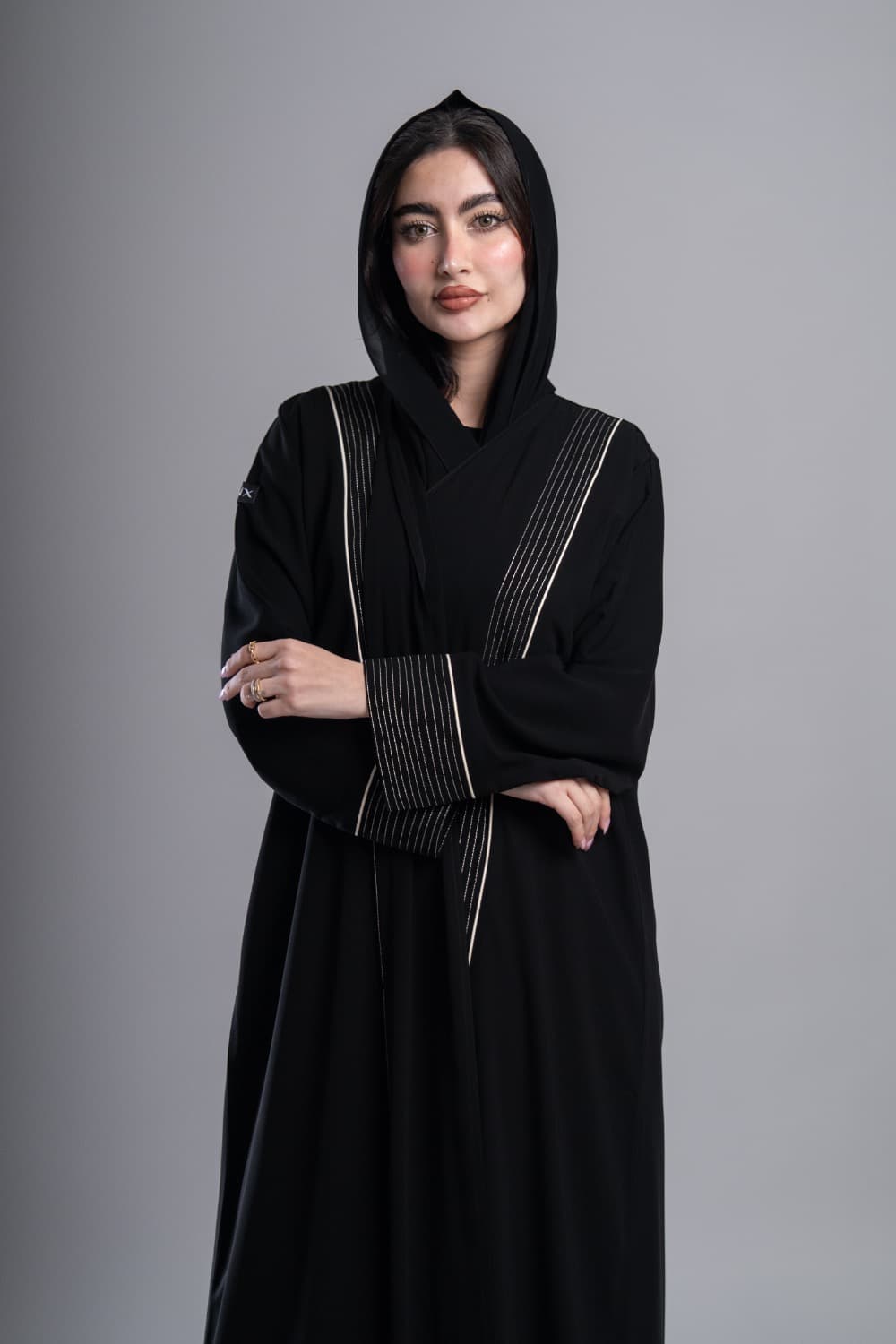 عباية كريب أسود بخطوط فضية وتطريز دقيق عباية كريب فاخر باللون الأسود تتميز بشريطين عموديين من التطريز الفضي الدقيق يمتدان من الكتف حتى أسفل العباية، مع خطوط رفيعة تمنحها طابعاً عصرياً وأنيقاً تطريز فضي وخطوط دقيقة تتخلل العباية خطوط تطريز فضية رفيعة تلمع عند انعكاس الضوء، محاطة بخطوط دقيقة تخلق تباينًا جميلاً مع الأسود، نفس التفصيل يظهر على الأكمام بشكل متناسق يرفع الإطلالة كاملة الطرحه المتناسقة لإكمال إطلالتك تأتي العباية مع طرحة شيفون باللون الأسود تتناسق مع العباية وتكمل الإطلالة بأناقة، ارتديها بثقة في العمل والمناسبات وكل يوم يستحق حضورك