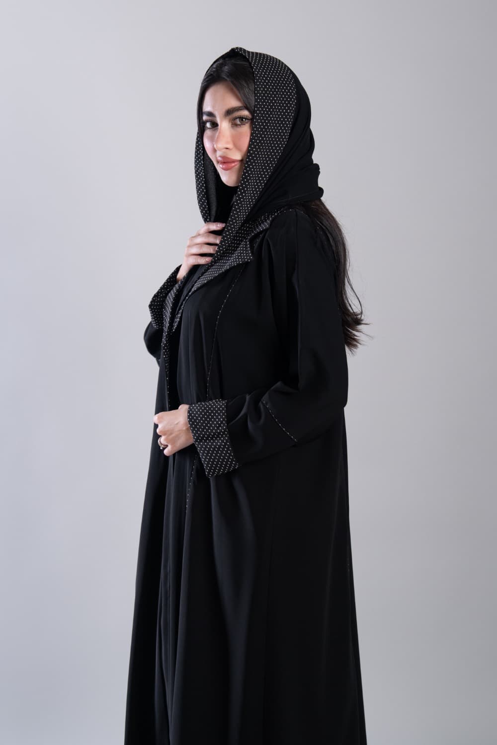 عباية كريب أسود ببولكا دوت أبيض
 إطلالة يومية راقية مع عباية باللون الأسود من قماش الكريب، تتميز بتفاصيل بولكا دوت أبيض على الياقة وأطراف الأكمام تضيف إليها طابعاً عصرياً محبباً، تصميم خفيف وأنيق يناسب كل يوم
 قماش كريب ناعم بتفاصيل بولكا دوت مميزة
 تتميز هذه العباية بقماش كريب ناعم ومطفي يمنحك خفة وراحة طوال اليوم، مع تفاصيل بولكا دوت أبيض على الياقة وأطراف الأكمام وخيوط بيضاء دقيقة على طول الأمام تمنحها تفصيلاً نظيفاً ومميزاً
 الطرحه المتناسقة لإكمال إطلالتك
 تأتي العباية مع طرحة تحمل نفس نقشة البولكا دوت تتناسق مع تفاصيل العباية وتكمل الإطلالة بأناقة، ارتديها في يومياتك وكل مناسبة تستحق اهتمامك