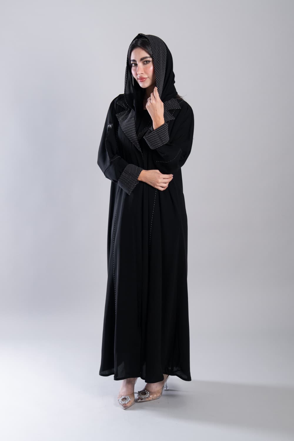 عباية كريب أسود ببولكا دوت أبيض
 إطلالة يومية راقية مع عباية باللون الأسود من قماش الكريب، تتميز بتفاصيل بولكا دوت أبيض على الياقة وأطراف الأكمام تضيف إليها طابعاً عصرياً محبباً، تصميم خفيف وأنيق يناسب كل يوم
 قماش كريب ناعم بتفاصيل بولكا دوت مميزة
 تتميز هذه العباية بقماش كريب ناعم ومطفي يمنحك خفة وراحة طوال اليوم، مع تفاصيل بولكا دوت أبيض على الياقة وأطراف الأكمام وخيوط بيضاء دقيقة على طول الأمام تمنحها تفصيلاً نظيفاً ومميزاً
 الطرحه المتناسقة لإكمال إطلالتك
 تأتي العباية مع طرحة تحمل نفس نقشة البولكا دوت تتناسق مع تفاصيل العباية وتكمل الإطلالة بأناقة، ارتديها في يومياتك وكل مناسبة تستحق اهتمامك