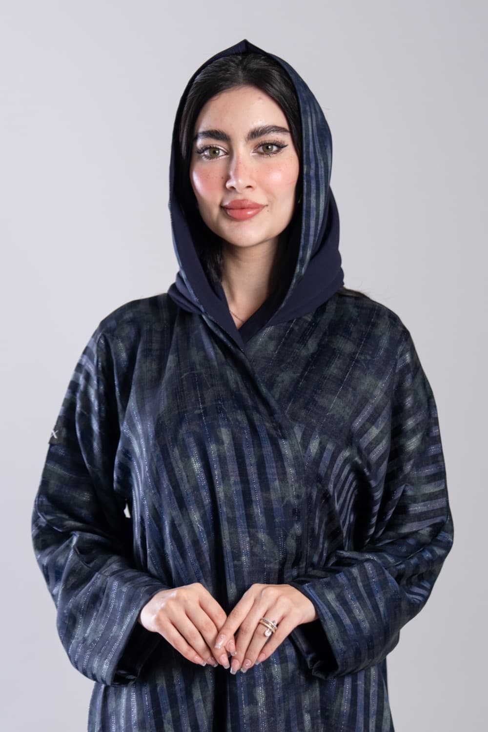 تصميم جاكار كحلي راقٍ بنقشات مميزةعباية باللون الكحلي من قماش جاكار فاخر بنقشات منسوجة تجمع بين الكحلي والأخضر الداكن مع خيوط لامعة دقيقة تعكس الضوء بشكل خفيف وأنيق، تصميم بسيط بدون إضافات يجعل الخامة نفسها هي التفصيل الأول والأخيرقماش جاكار فاخر بلمعة دقيقةيتميز هذا التصميم بقماش جاكار ناعم بنقشات خطوط منسوجة بألوان متناسقة من الكحلي والأخضر الداكن، مع خيوط لامعة مدمجة في النسيج تضيف بريقاً هادئاً، قطعة تلفت النظر من أول نظرةالطرحه المتناسقة لإكمال إطلالتكتأتي العباية مع طرحة ناعمة باللون الكحلي تتناسق مع العباية وتكمل الإطلالة بأناقة، ارتديها في يومك اليومي وكل مناسبة تستحق حضورك