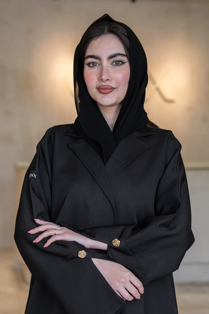 تصميم بليزر فاخر بلمسة ذهبية تألقي بإطلالة راقية مع عباية قماش باربي فاخر باللون الأسود، مصممة بقصّة بليزر عصرية تجمع بين الأناقة الهادئة والحضور القوي، ياقة واسعة بارزة تمنحك مظهراً مميزاً في كل مناسبة قماش باربي فاخر بسمك يعكس الفخامة تتميز هذه العباية بقماش باربي فاخر ذو ملمس مطفي وسمك واضح يعطي الإطلالة ثقلاً وفخامة حقيقية، أكمام بثنيات مزيّنة بأزرار ذهبية على شكل وردة تضيف تفصيلاً دقيقاً يرفع الإطلالة كاملة الطرحه المتناسقة لإكمال إطلالتك لإضافة لمسة ختامية لإطلالتك، تأتي العباية مع طرحة باللون الأسود تتناسق تماماً مع العباية وتكمل الإطلالة بأناقة، ارتديها بثقة في العمل والمناسبات وكل يوم يستحق حضورك